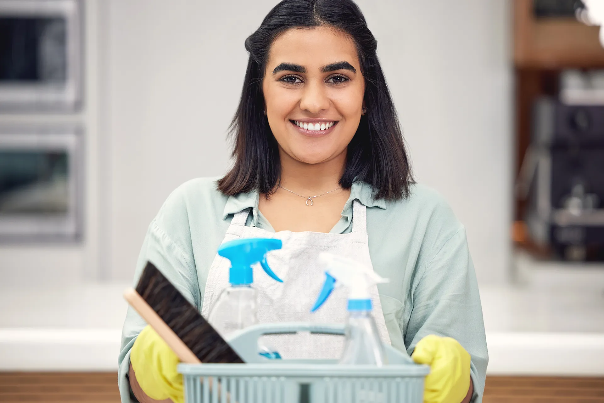 Girl Smiling and Holding Cleanign Supplies